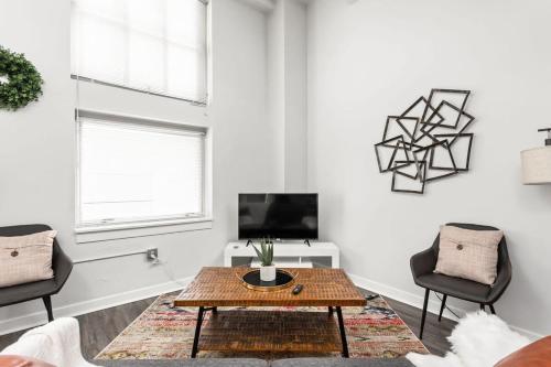 sala de estar con mesa de centro y 2 sillas en Modern Downtown Apartment 2BR 2BA by CozySuites, en Indianápolis