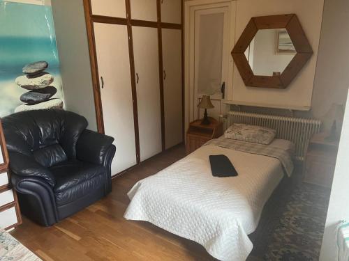 a bedroom with a bed and a chair and a mirror at Stop at The Cross in Borås