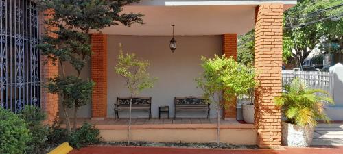two benches sitting on the porch of a house at Hotel Plaza Kavia in Santo Domingo