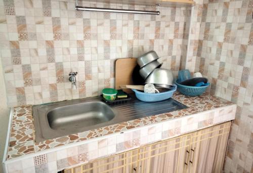 a kitchen counter with a sink and utensils at M&M HOMES in Naivasha