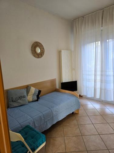 a bedroom with a blue bed and a television at Appartamento Caracola in Lignano Sabbiadoro