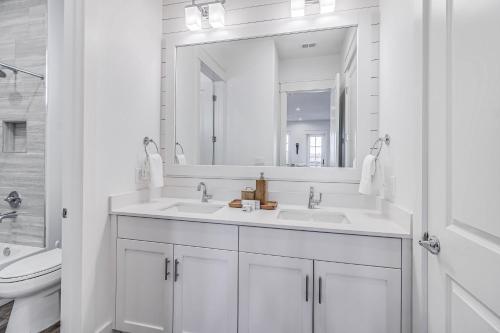 a white bathroom with two sinks and a mirror at Spanish Dagger Serenity in Port Aransas