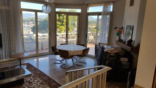 un salon avec une table et une grande fenêtre dans l'établissement Villa sur le toit, à Saint-Mandrier-sur-Mer
