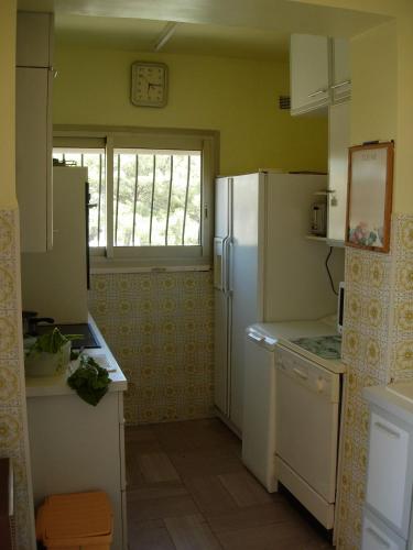 une cuisine avec un réfrigérateur blanc et une fenêtre dans l'établissement Villa sur le toit, à Saint-Mandrier-sur-Mer
