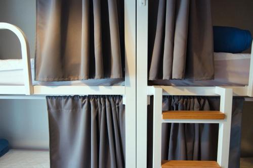 a bedroom with a bunk bed with a curtain at Factory Hostels Barcelona in Barcelona