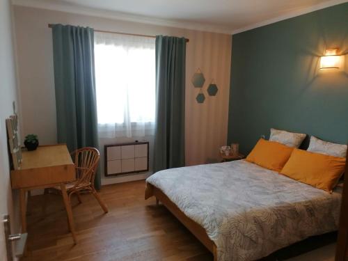 une chambre avec un lit, un bureau et une fenêtre dans l'établissement La Villa Corentine, à Grand-Corent