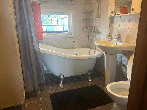 a bathroom with a tub and a sink and a toilet at Stop at The Cross in Borås