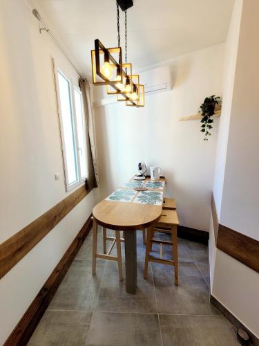 une salle à manger avec une table et un lustre dans l'établissement 23 Centre historique - Gare - Place de la Comédie, à Montpellier