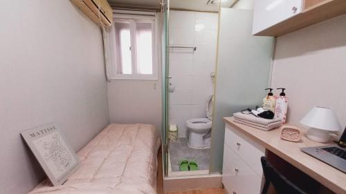 a small bathroom with a shower and a toilet at Haechi Stay GuestHouse - For foreigners only in Seoul