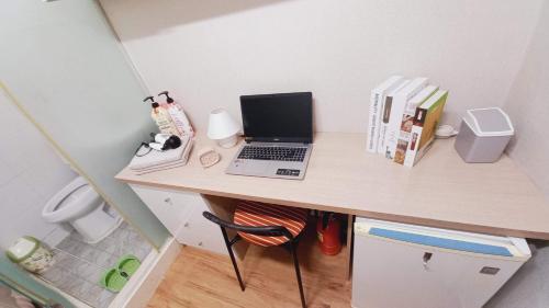 a desk with a laptop computer on top of it at Haechi Stay GuestHouse - For foreigners only in Seoul