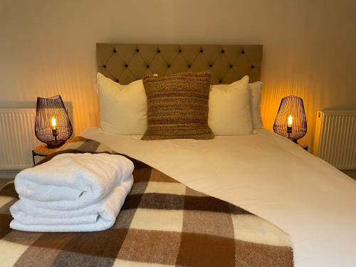 a bedroom with a large bed with two lamps at The wing at Old Hundred in Tormarton
