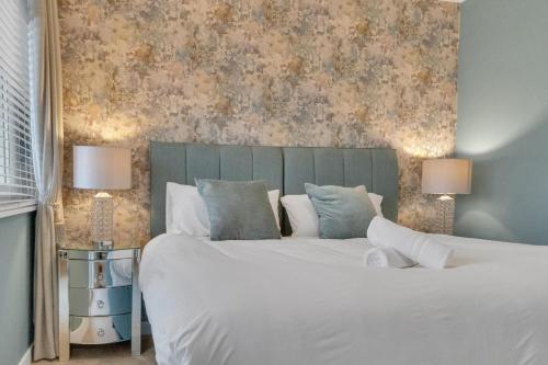 una camera da letto con un grande letto bianco con due lampade di Coastal Sunset By My Getaways a Brighton & Hove