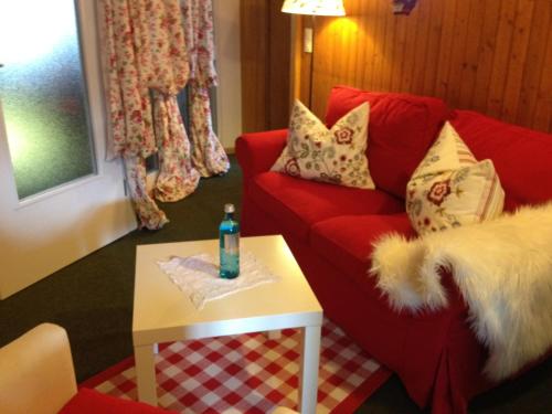 a living room with a red couch and a table at Mattenhof in Zell am Harmersbach