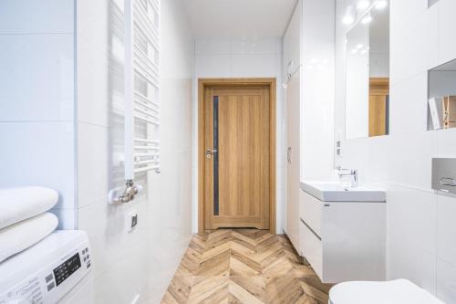 a white bathroom with a toilet and a sink at Apartamenty pod Orłem - Rezydencja Modern in Zakopane