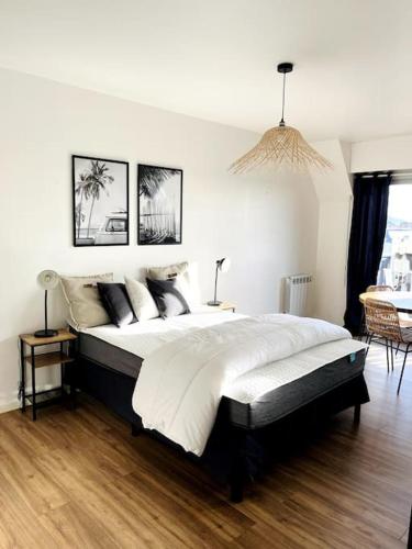 une chambre avec un grand lit dans une pièce dans l'établissement studio à deux pas de la plage et des commerces, à Cabourg