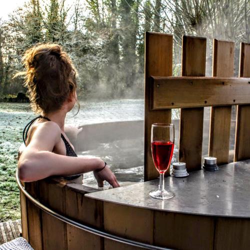une femme assise à une table avec un verre de vin dans l'établissement Ferme du Moulin de Paillères, vue panoramique, piscine - idéal 4 à 5 personnes, à Galapian
