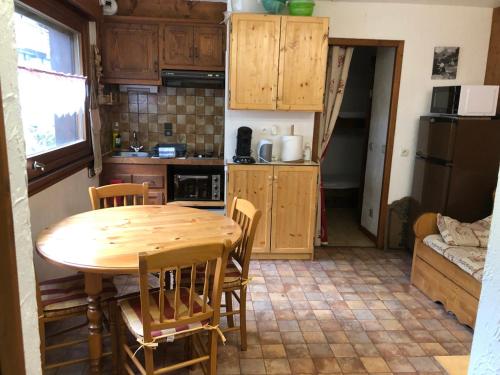 une petite cuisine avec une table et des chaises en bois dans l'établissement Princesse jonquille, à Demi-Quartier