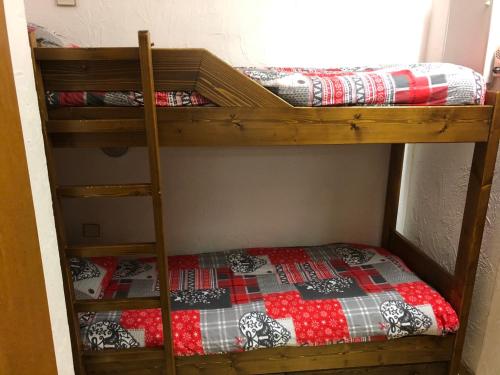 a bunk bed with a quilt on the bottom bunk at Princesse jonquille in Demi-Quartier