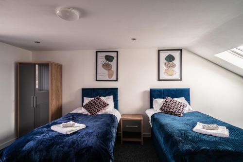 a room with two beds with towels on them at Refined Comforts for Two Room 5 in Manchester