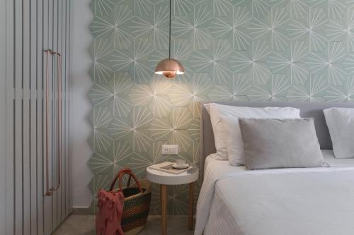 a bedroom with a bed and a blue and white wall at Phāea Cretan Malia, a Member of Design Hotels in Malia