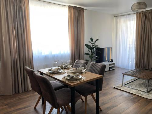 uma mesa de jantar e cadeiras numa sala de estar em Saulės Tako apartamentai em Druskininkai