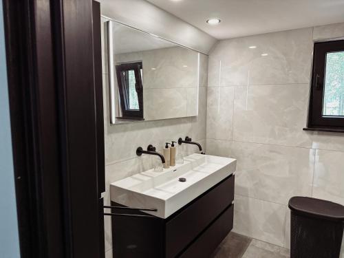 La salle de bains est pourvue d'un lavabo blanc et d'un miroir. dans l'établissement CortenHuys, à Enschede