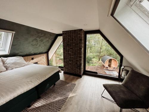 1 dormitorio con ventana grande, cama y silla en CortenHuys en Enschede