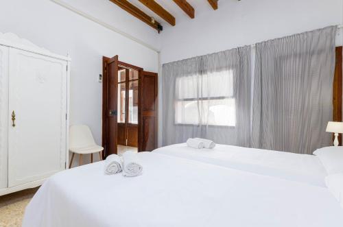 Dos camas blancas en una habitación con ventana. en YourHouse Ca Mado Josefa house, en Santa Margalida