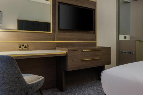 a bedroom with a desk with a tv and a bed at DoubleTree by Hilton London Angel Kings Cross in London