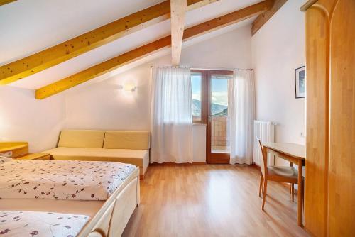 1 dormitorio con 2 camas, mesa y escritorio en Fröhlichhof Wohnung Panorama en Lagundo