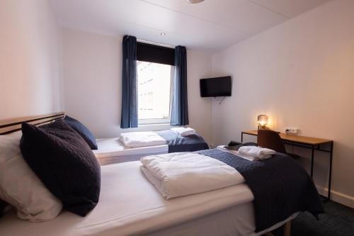a hotel room with two beds and a window at Milling Hotel Mini 19 in Odense