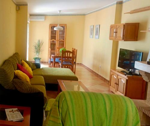 sala de estar con sofá y TV en Chalet adosado con azotea andaluza y patio, junto a la playa, en Isla Cristina