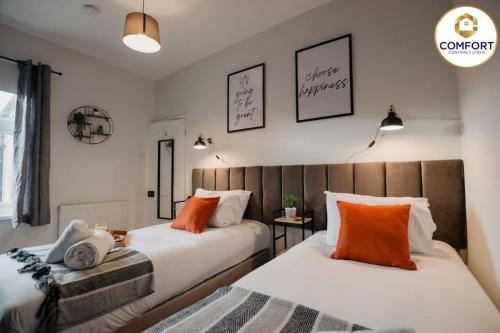 2 camas con almohadas de color naranja en un dormitorio en 20% off Monthly Stays 2 Bedroom Townhouse en Nottingham