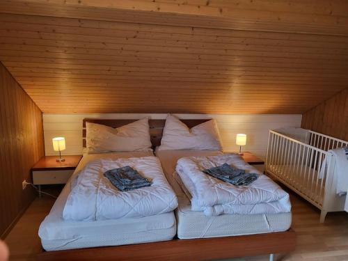 a large bed with two pillows on it in a room at Ferienhaus in der Natur in Schlossrued