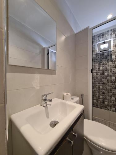 a white bathroom with a sink and a toilet at Maison d'hôte Bousaid in Chefchaouene