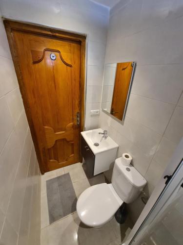 a bathroom with a toilet and a wooden door at Maison d'hôte Bousaid in Chefchaouene