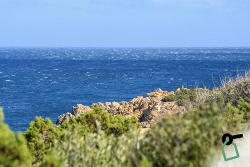 a view of the ocean from atop a cliff at Hotiday Room Collection - Porto Cervo in Porto Cervo
