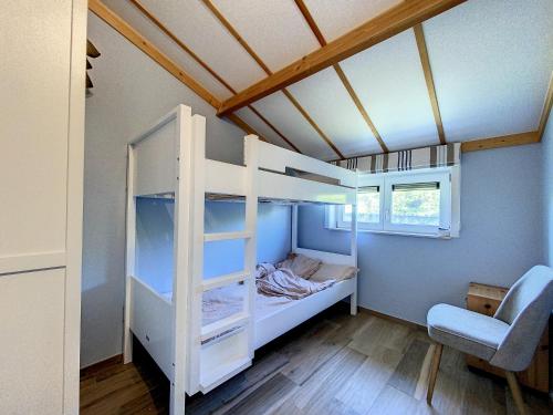 ein kleines Schlafzimmer mit einem Etagenbett in einem Haus in der Unterkunft Vissershuisje 'Duinengolf' in Oostduinkerke