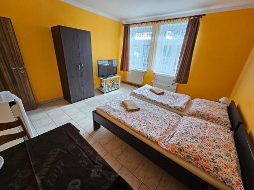 a bedroom with two beds and a flat screen tv at Ubytování Jeřábek in Lasenitz