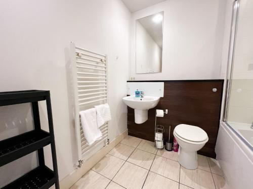 a white bathroom with a toilet and a sink at Central Gem 1 Bed Flat City Centre in Glasgow