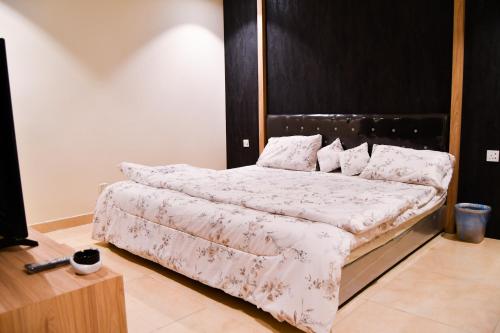 um quarto com uma cama e uma cabeceira em madeira em Stylish and private apartment em Riyadh