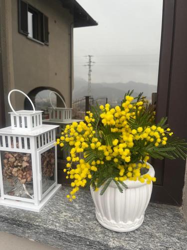 a white vase filled with yellow flowers on a balcony at Tenuta Rella in Dronero