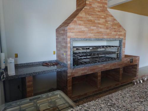 a brick fireplace in a living room at Linda Casa Jardim - 500 Mts da Praia in Navegantes