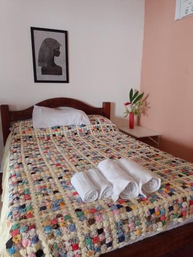 a bed with two towels and two pairs of slippers at CHALE PERTO DA PRAIA COM DUAS SUITES E VARANDAO in Pacatuba