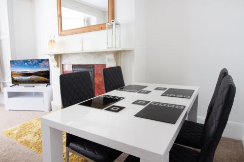 a dining room with a white table and chairs at OPP Exeter - Cosy 1 bed with parking, BIG SAVINGS booking 7 nights or more! in Exeter