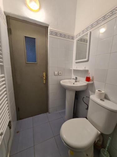 a white bathroom with a toilet and a sink at Maison d'hôte Bousaid in Chefchaouene
