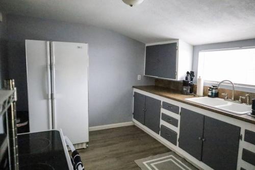 a kitchen with a refrigerator and a sink at The Main Nest - Near City Center in Klamath Falls