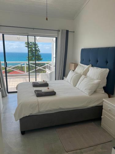 a bedroom with a large bed with a view of the ocean at Surfstar at Mimosa Jeffreys Bay in Jeffreys Bay