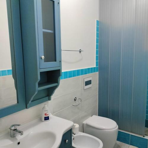 bagno con lavandino, servizi igienici e specchio di PM 22 Via Cala Sabina Guest House a Stintino