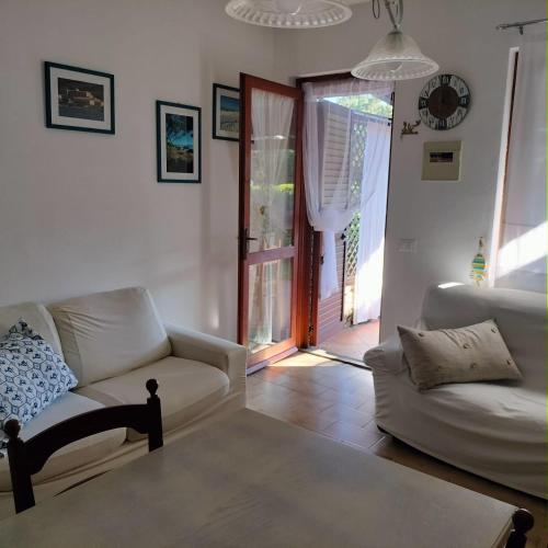 un soggiorno con divano e sedia di PM 22 Via Cala Sabina Guest House a Stintino